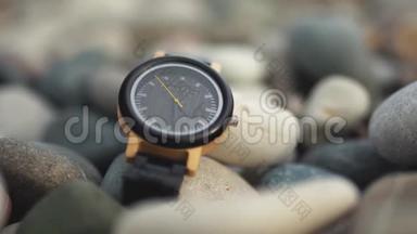 豪华黑色手表与黑色手表带在海滩石头。